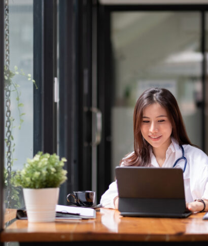 Portrait happy asian woman doctor in hospital, female using smart digital tablet