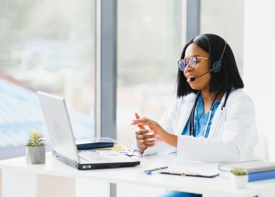 Young African-American doctor working on laptop in clinic